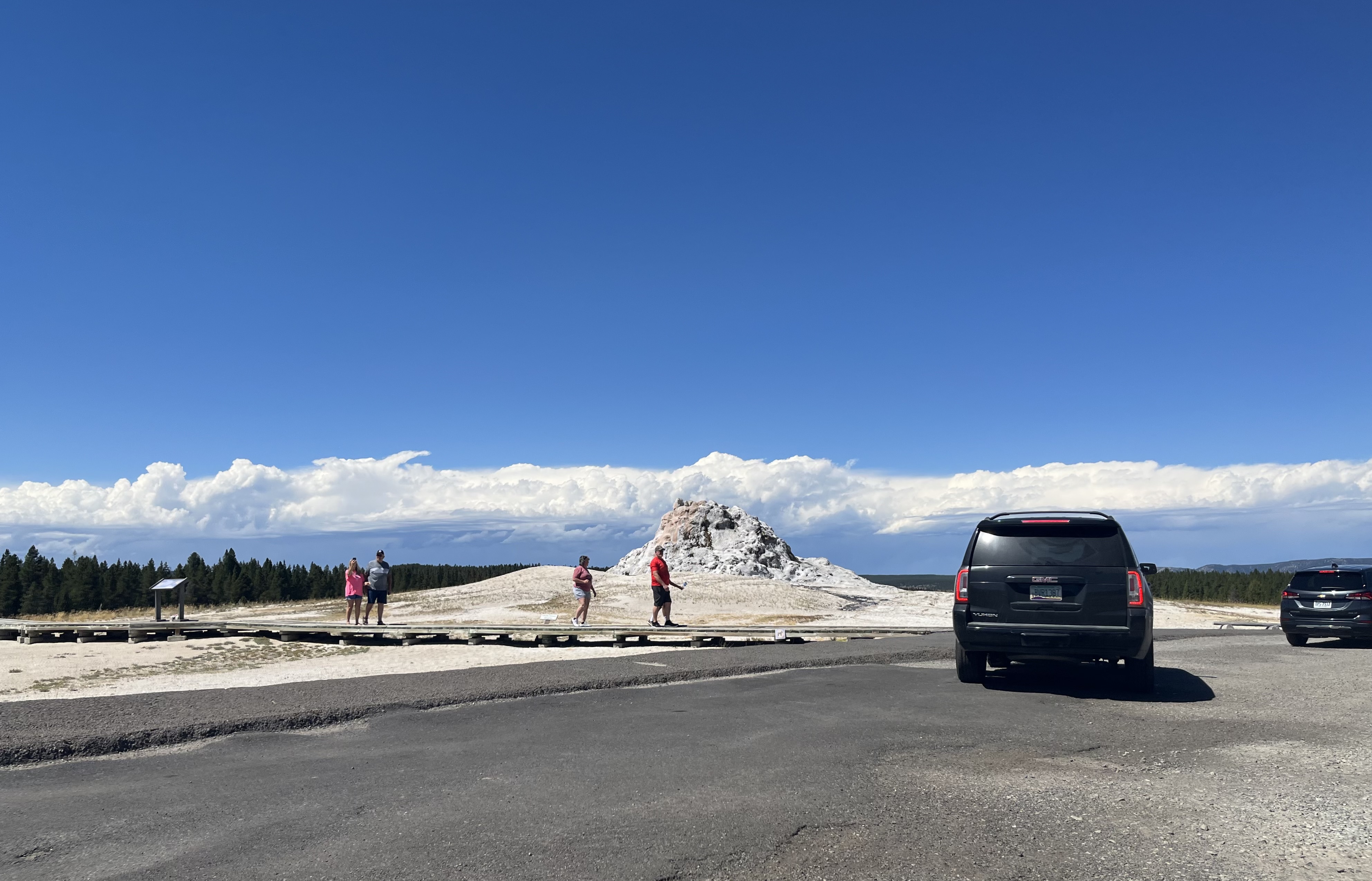 White geothermal mound with cars nearby