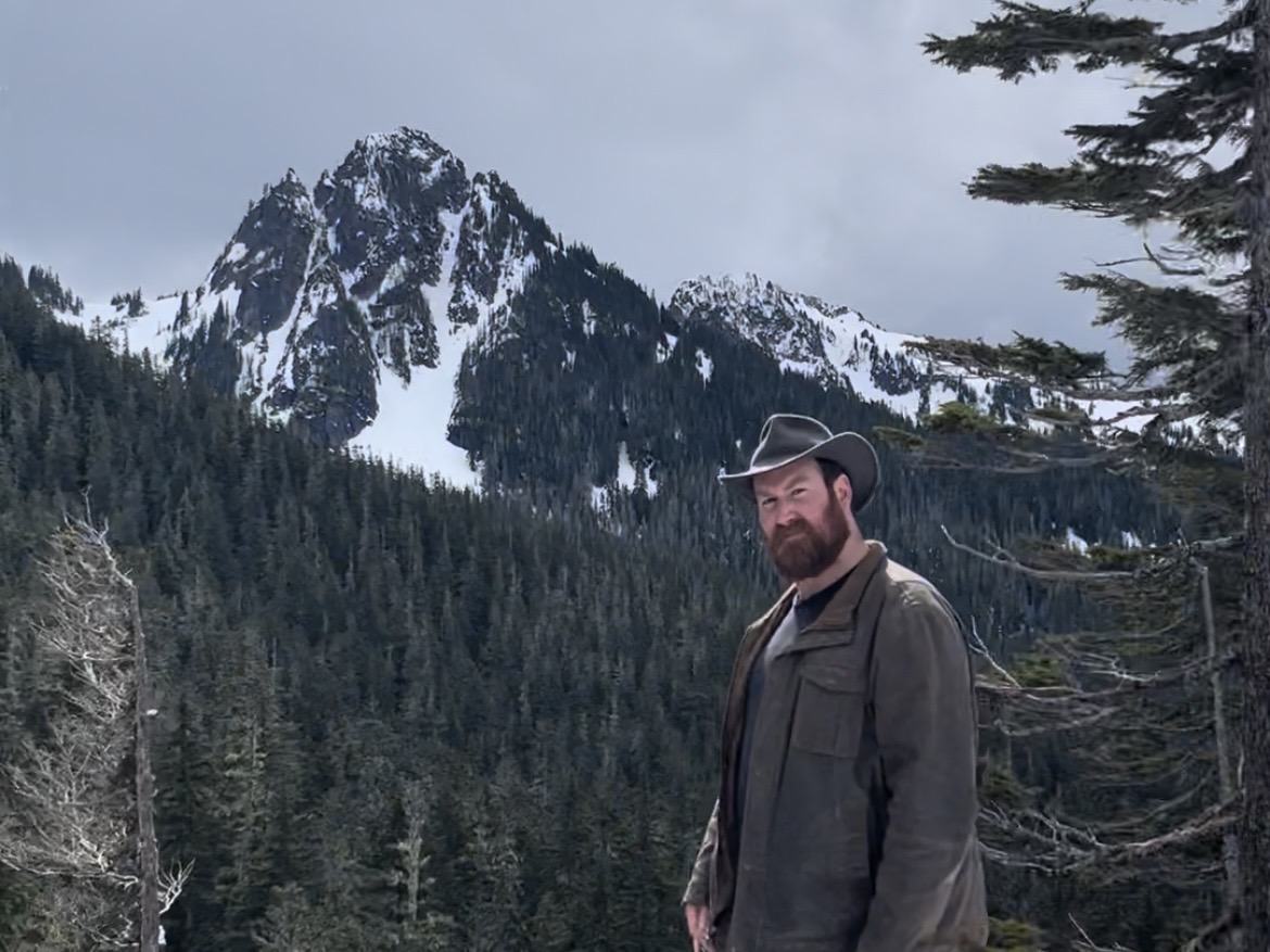 Person standing in front of snowy mountain